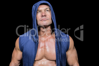 Muscular man in blue hood looking up