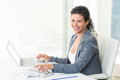 Portrait of confident pregnant businesswoman working in office