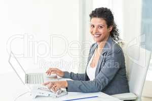 Portrait of confident pregnant businesswoman working in office