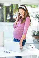 Happy businesswoman using cellphone and laptop