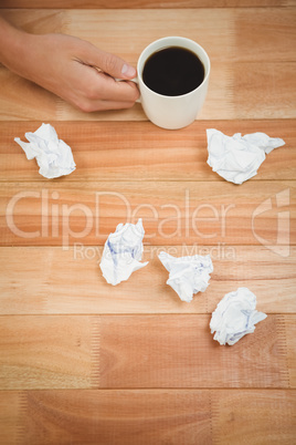 Businessman holding black coffee cup on desk