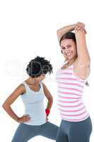 Fit woman exercising while female friend stretching