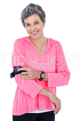 Portrait of happy woman using mp3 player in armband
