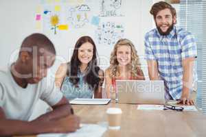 Portrait of happy business professionals working at desk