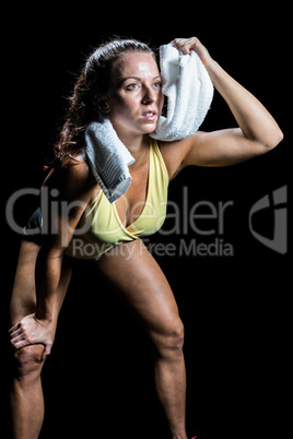 Athlete wiping sweat with towel while looking up