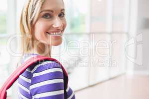 Portrait of happy young female student in college