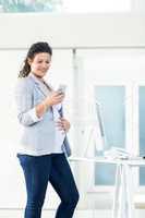 Confident pregnant businesswoman using phone