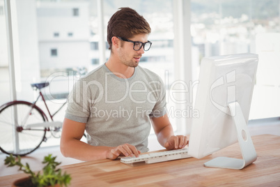 Hipster working on computer at desk Hipster working on computer at desk