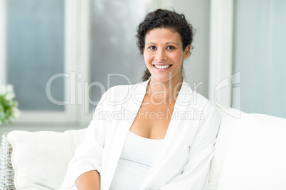 Portrait of happy woman sitting on sofa