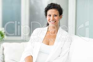 Portrait of happy woman sitting on sofa