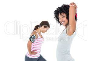 Woman stretching while female friend exercising