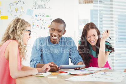 Smiling business professionals using digital tablet at desk