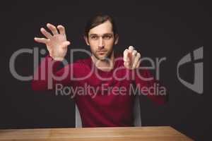 Man gesturing while sitting at desk