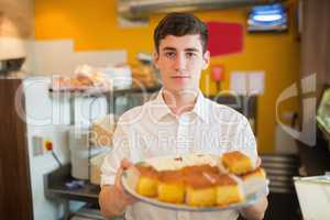Male worker with pastries in bakery