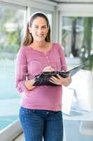 Portrait of pregnant businesswoman with diary