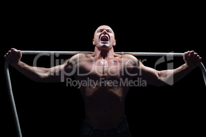 Aggressive man with arms outstretched holding rope