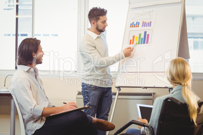 Smart businessman giving presentation as colleagues looking at i