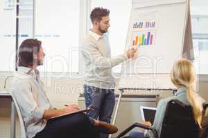 Smart businessman giving presentation as colleagues looking at i