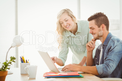 Happy young man and woman working on laptop