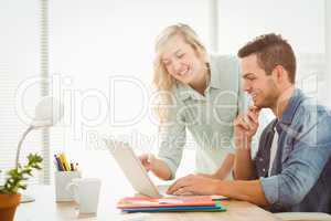 Happy young man and woman working on laptop