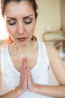 Peaceful woman meditating with joined hands