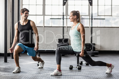 Male trainor with woman using dumbbells exercising