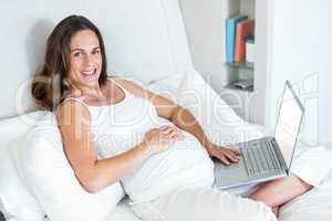 Portrait of pregnant woman with laptop