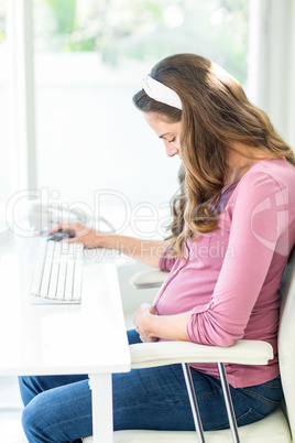 Side view of pregnant woman sitting on chair