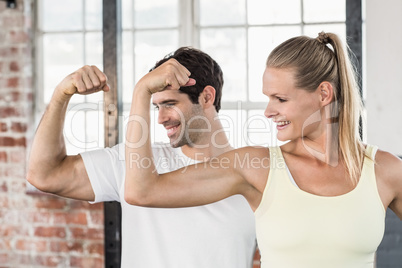 Couple flexing muscles at the gym