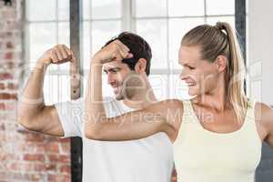 Couple flexing muscles at the gym