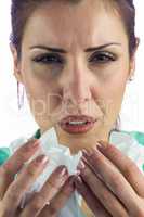 Close-up portrait of sneezing woman holding tissue