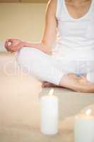 Meditating woman with illuminated candles