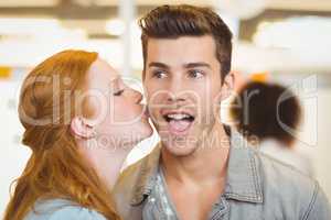 Woman kissing businessman