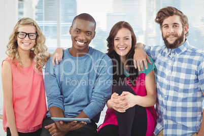 Portrait of cheerful business people with man holding digital ta