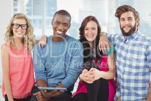 Portrait of cheerful business people with man holding digital ta