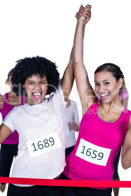 Portrait of cheerful winner athletes crossing finish line with a