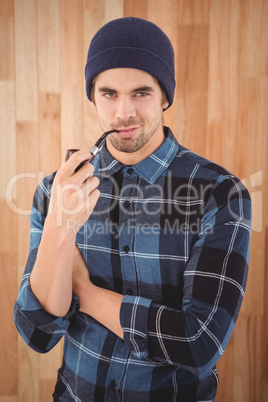 Portrait of confident hipster smoking pipe