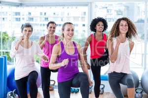 Portrait of smiling women exercising with clasped hands