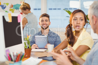 Businessman using digital PC surrounded with colleagues