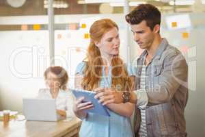 Businesswoman showing digital PC to businessman
