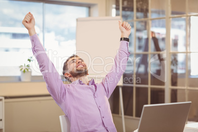 Businessman with arms raised looking up