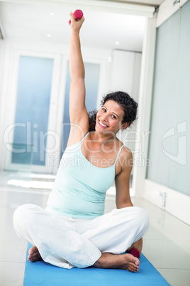 Portrait of pregnant woman lifting weight