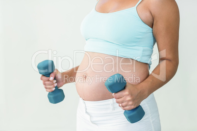 Pregnant woman lifting dumbbells