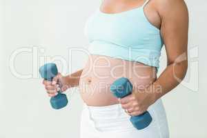 Pregnant woman lifting dumbbells