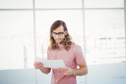 Confident hipster looking at documents