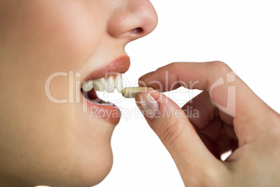 Woman taking pill on white background
