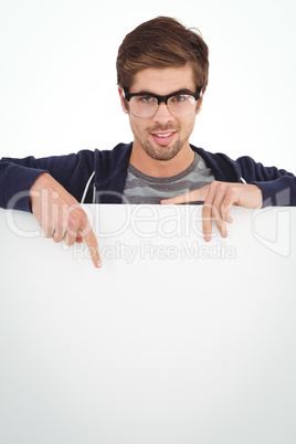 Portrait of man wearing eyeglasses pointing on billboard