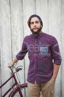 Portrait of confident hipster with bicycle