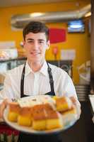 Confident male worker with pastries in bakery