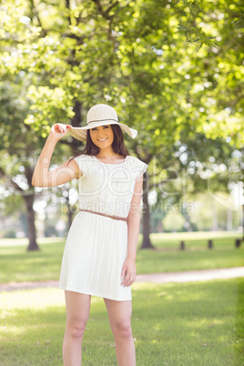 Portrait of confident happy woman holding sun hat